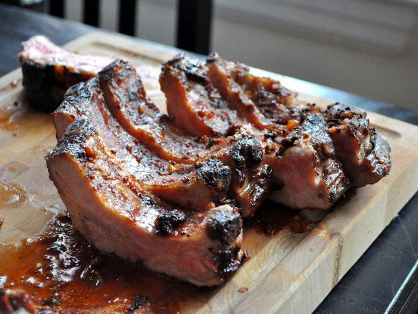 Bourbon baby back ribs, carved into individual ribs on a cutting board and ready to serve.