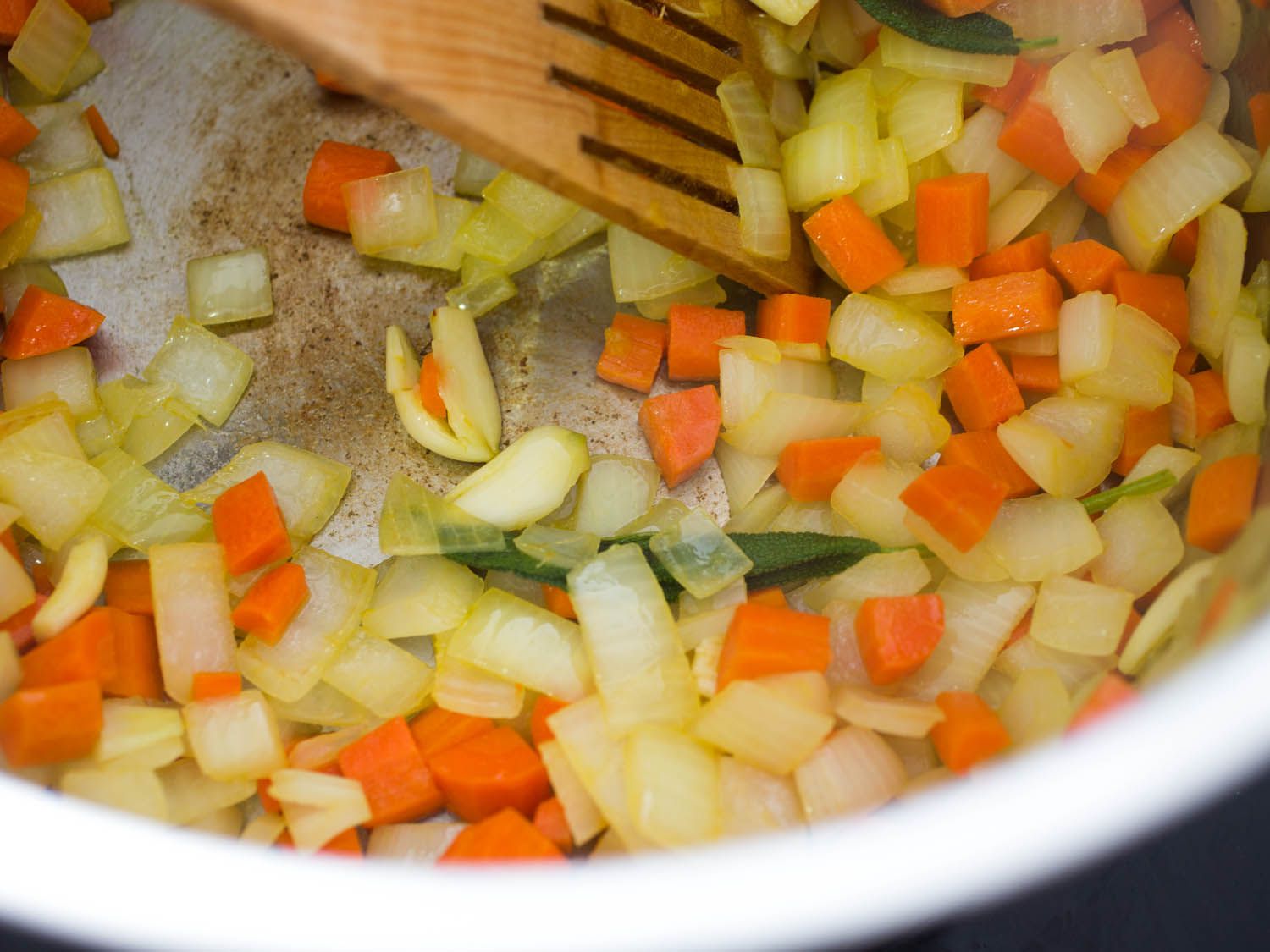 Carrot and onion sauteing in a pan. 