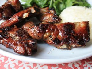 Closeup of Thai style grilled pork neck plated with rice and greens.