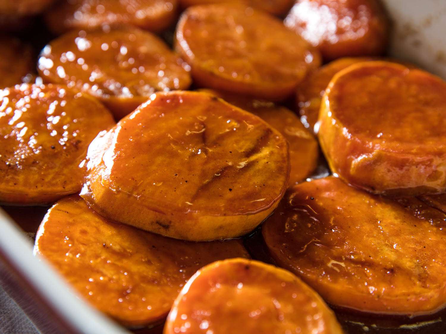 A close-up photograph of candied yams (sweet potatoes).