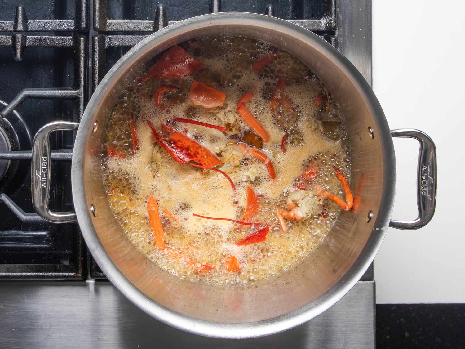 The lobster bodies boiling in liquid to make the lobster stock.