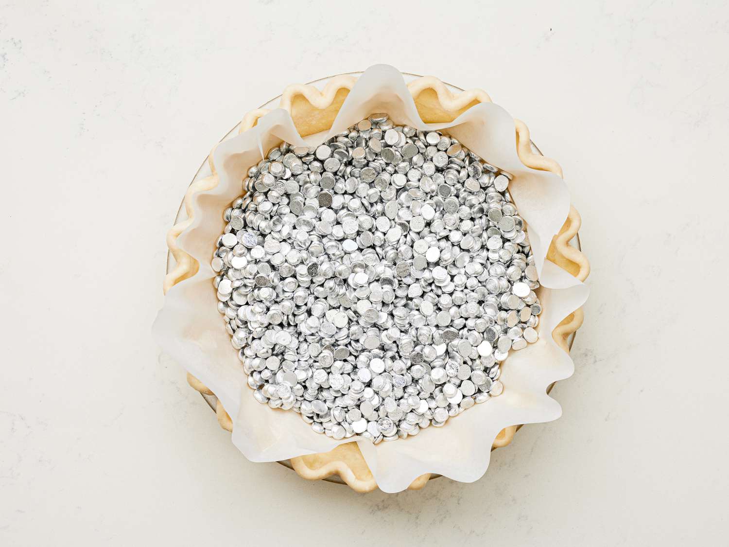 Overhead view of pie crust filled with pie weights