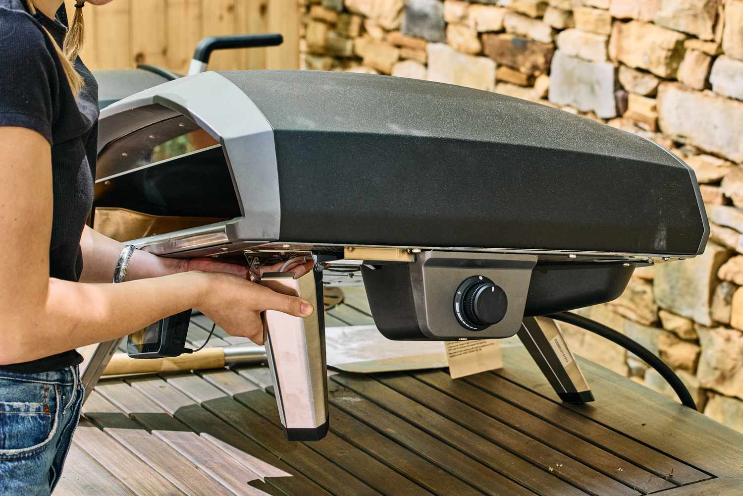 A person checks the legs on the Ooni Koda 2 Pro Gas-Powered Pizza Oven