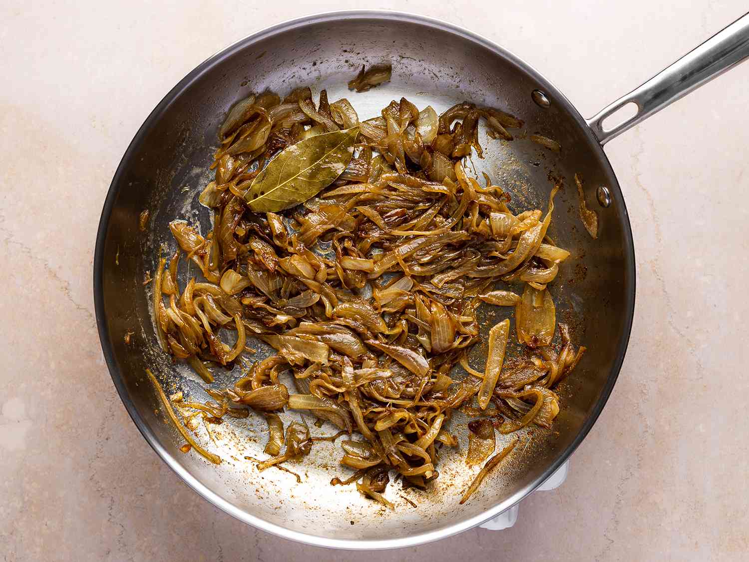 Onions and bay leaf cooking in a pan