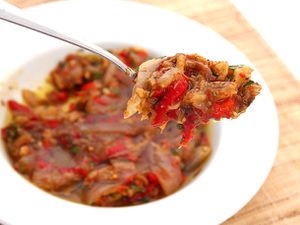 A spoonful of escalivada is held up for the camera.