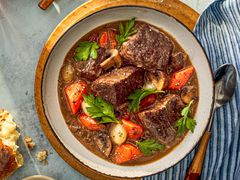 A bowl of beef bourguignon with big chunks of juicy beef, plump carrots, mushrooms and more.