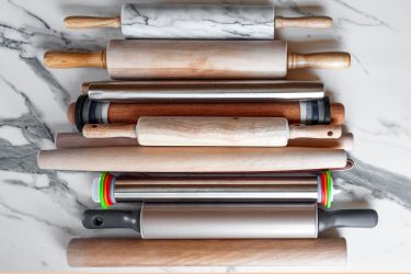 Assorted rolling pins arranged on a marble surface