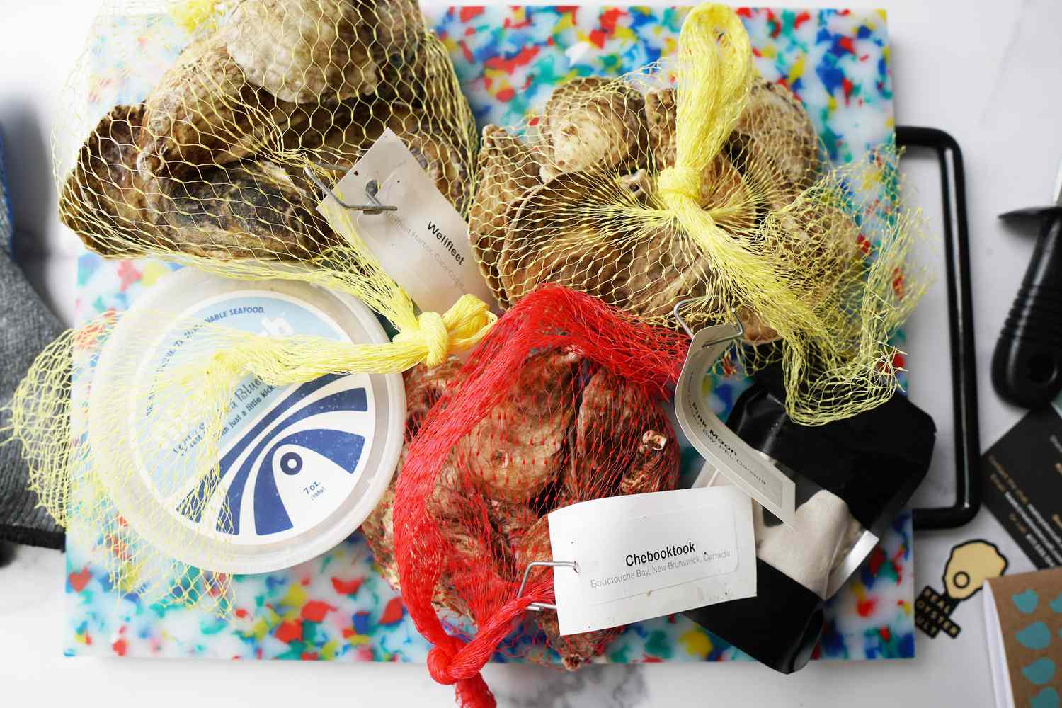 three bags of oysters on a colorful cutting board