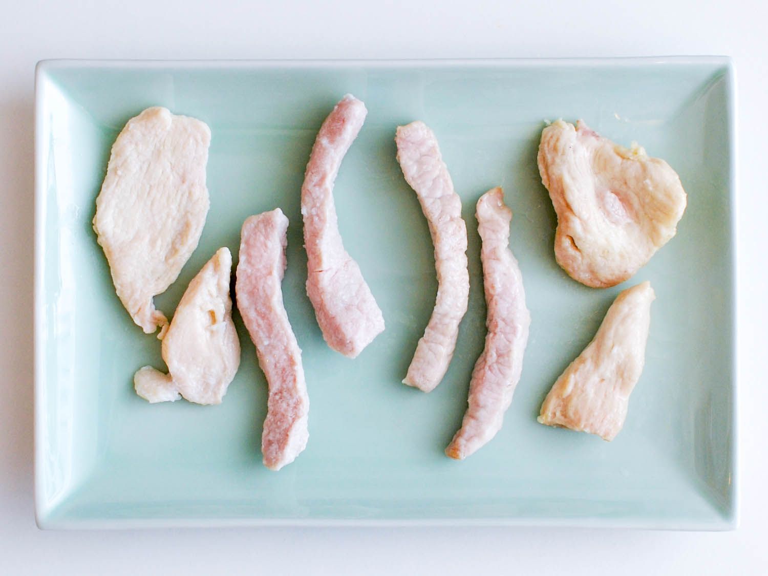 A plate full of water-blanched and oil-blanched pork and chicken.