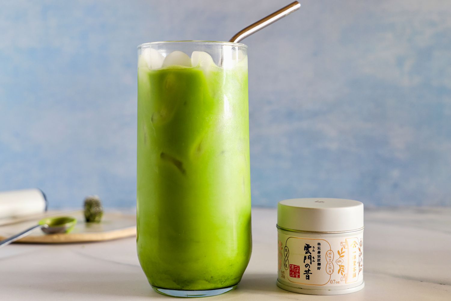 A glass of Ippodo Tea Ummon Matcha next to the container