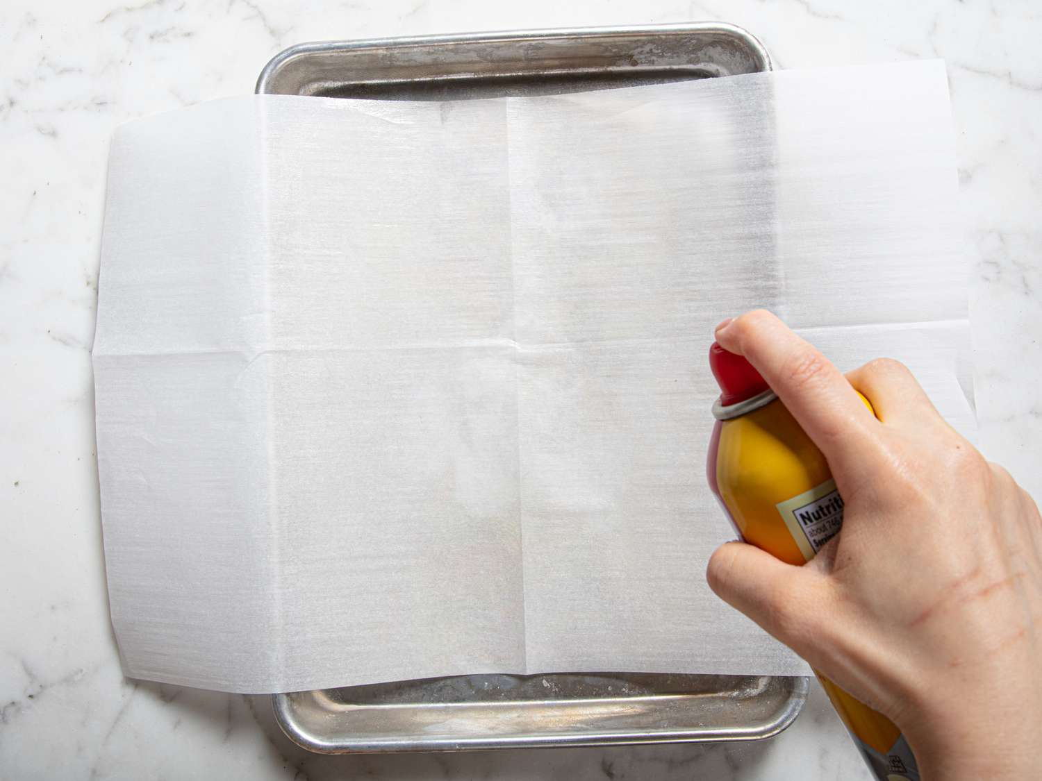 Overhead view o spraying parchment paper