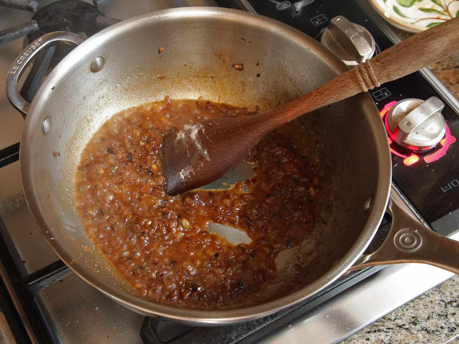 Cumin and mustard-seed flecked onions caramelizing in a large saucepan.