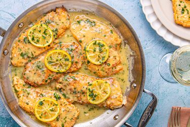Chicken Francese served in a pan with lemon slices and sauce