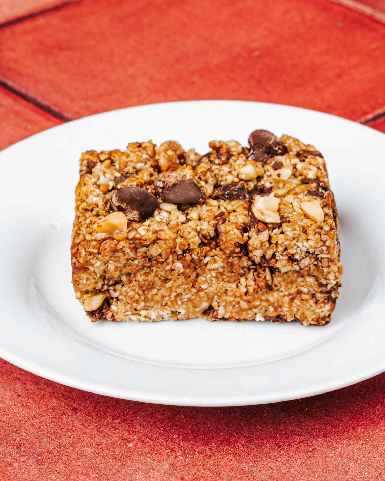 Chewy peanut butter oat bar with chocolate chips on a white plate