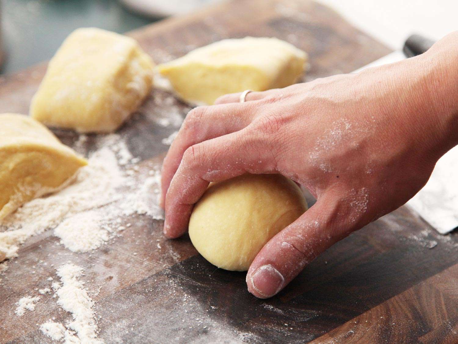 A portion of cemita dough is rolled into a ball.,