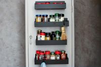Four magnetic spice racks attached to a metal door