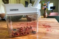A closeup of the Leifheit cherry pitter with cherry pits in the bottom