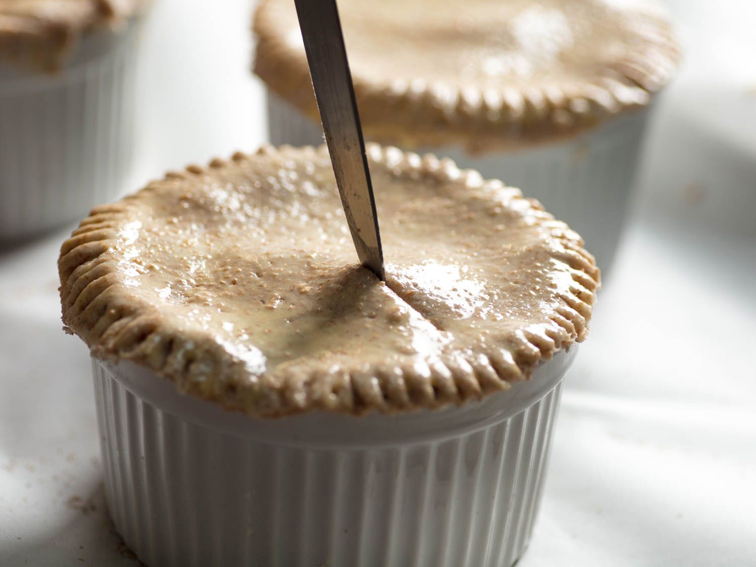 Cutting steam vents into the pastry top of a chicken pot pie.