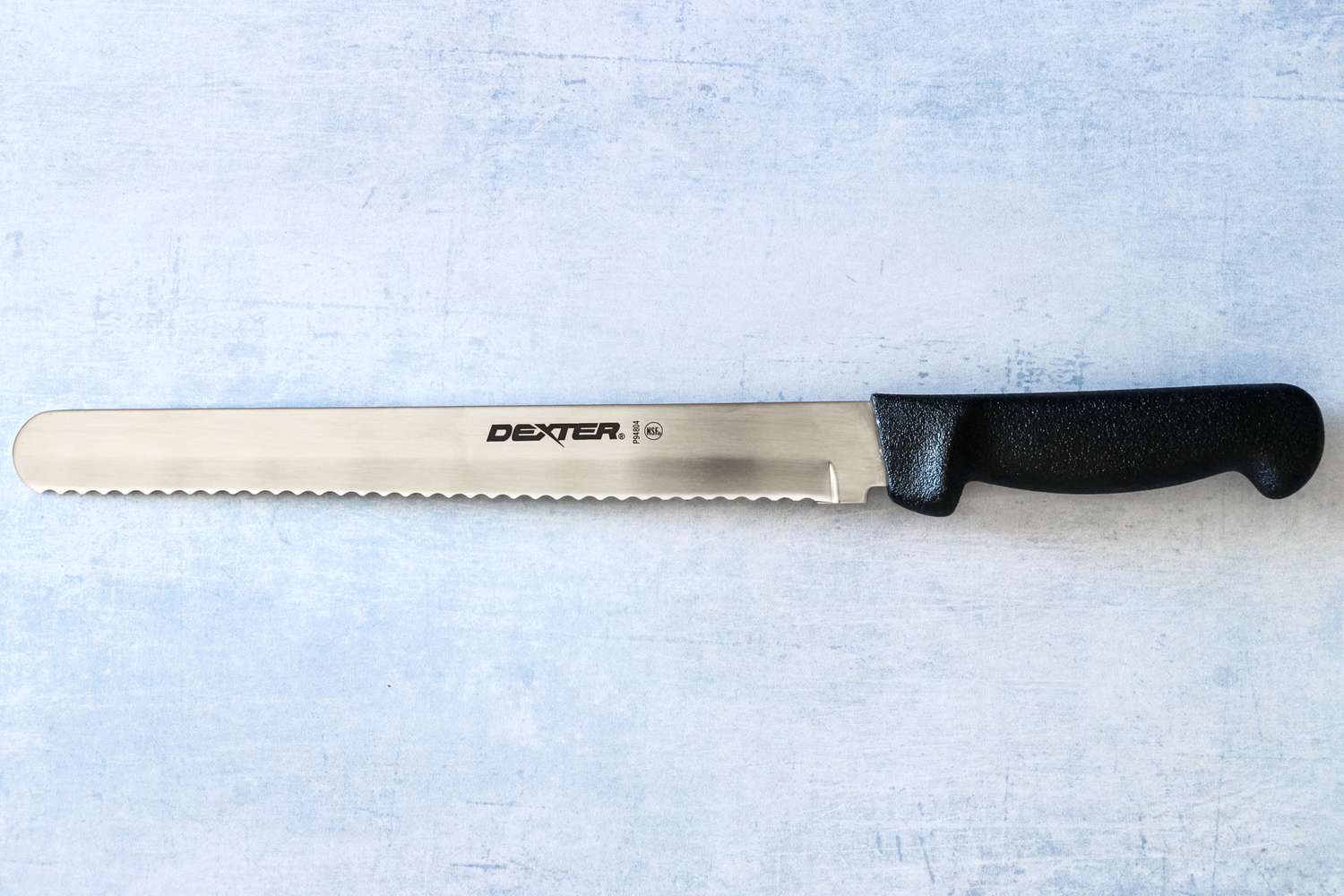 Dexter-Russell Basics 10-Inch Bread Knife With Black Polypropylene Handle on table