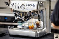The Breville Barista Express Impress brewing an espresso into a glass 