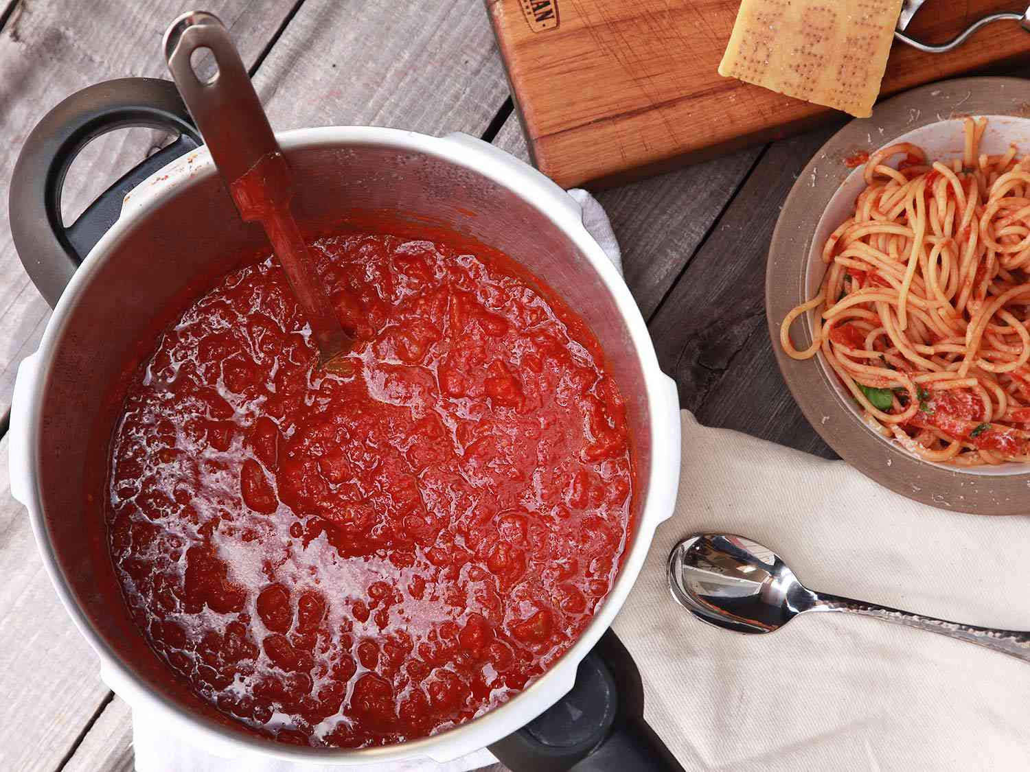 Pot of pressure cooker tomato sauce with ladle.