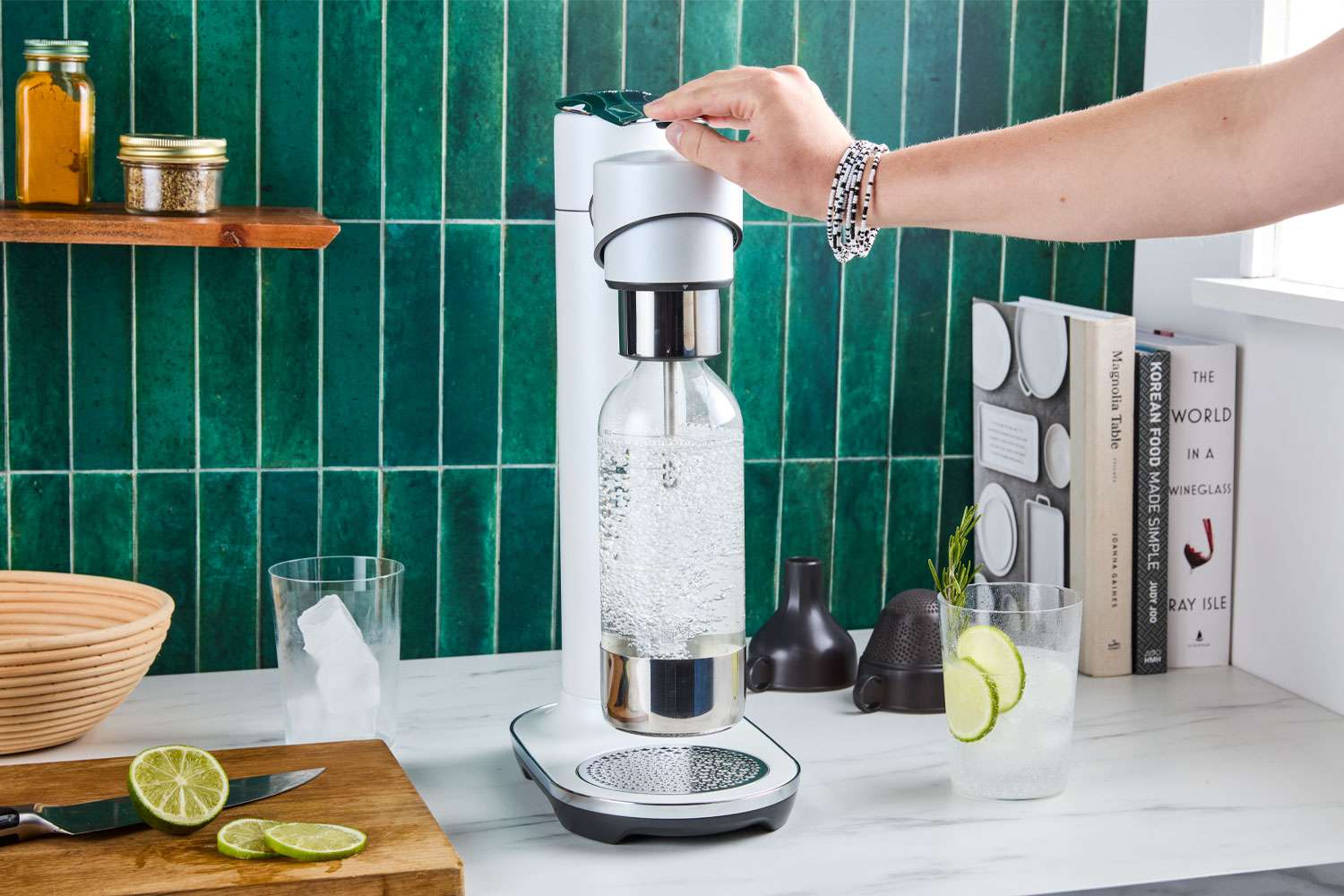 A person carbonating water with a soda maker.