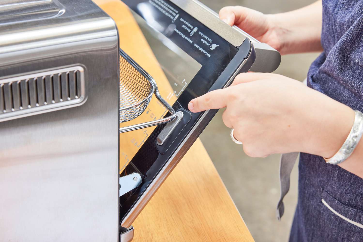 A close-up of a person opening the Breville the Smart Oven Air Fryer door