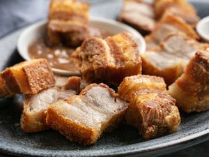 A close up of lechon kawali (Filipino crispy pork belly) on a plate.