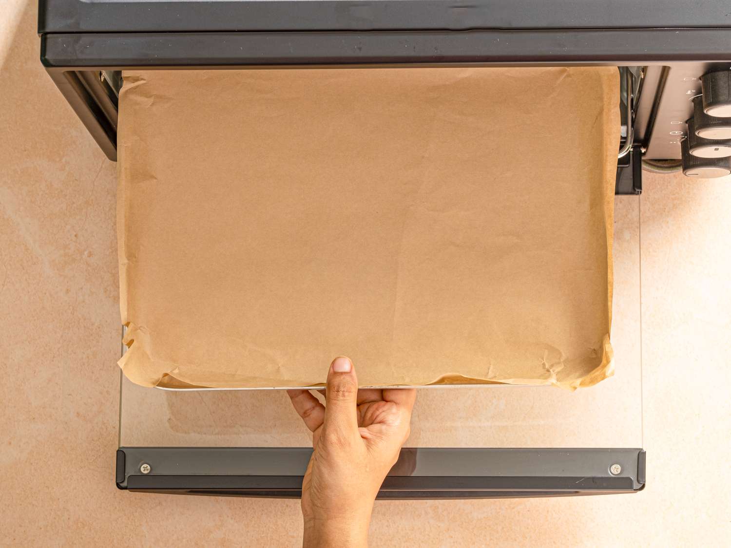 A person placing a parchmentlined baking sheet into an oven
