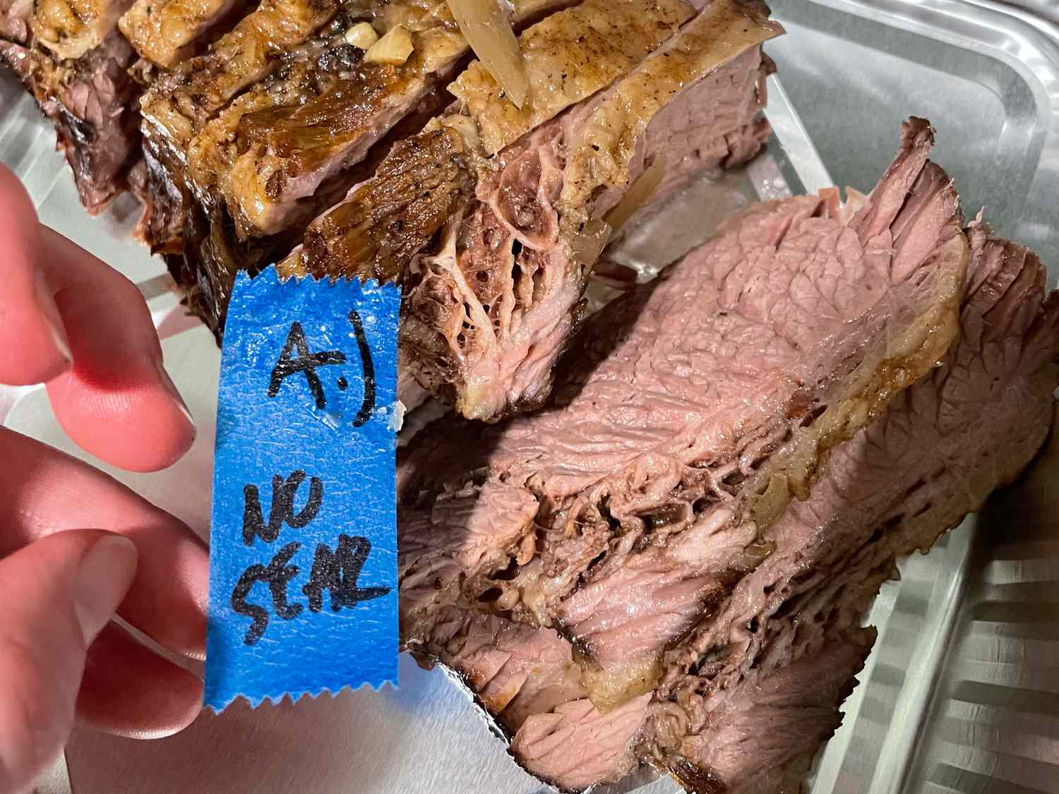 Sliced cooked meat labeled as not seared on a tray