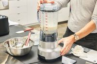 A person uses the Breville Fresh & Furious Blender