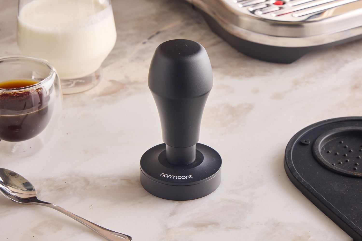 The Normcore tamper on a marble kitchen countertop.
