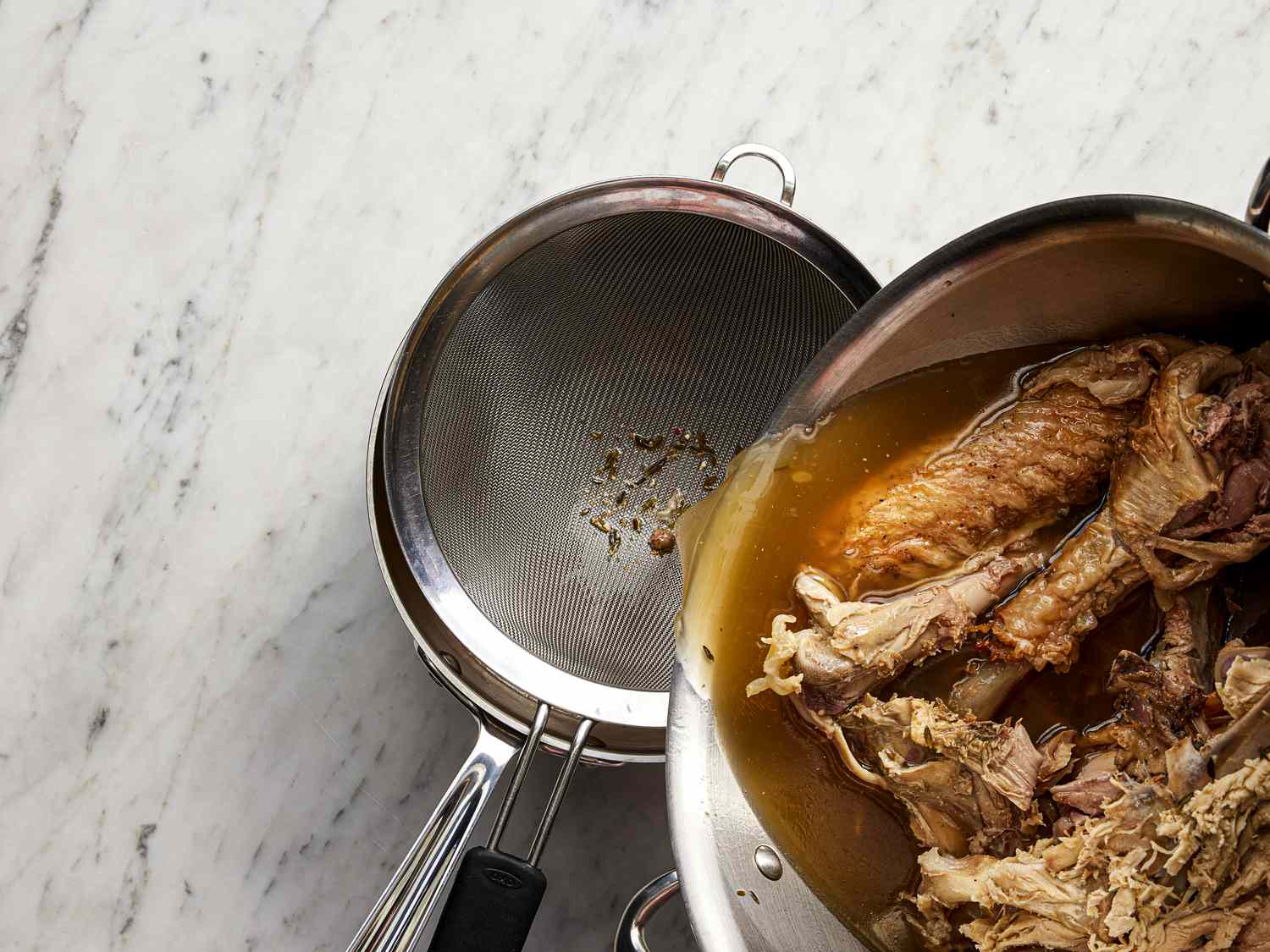 Straining broth into a saucepan