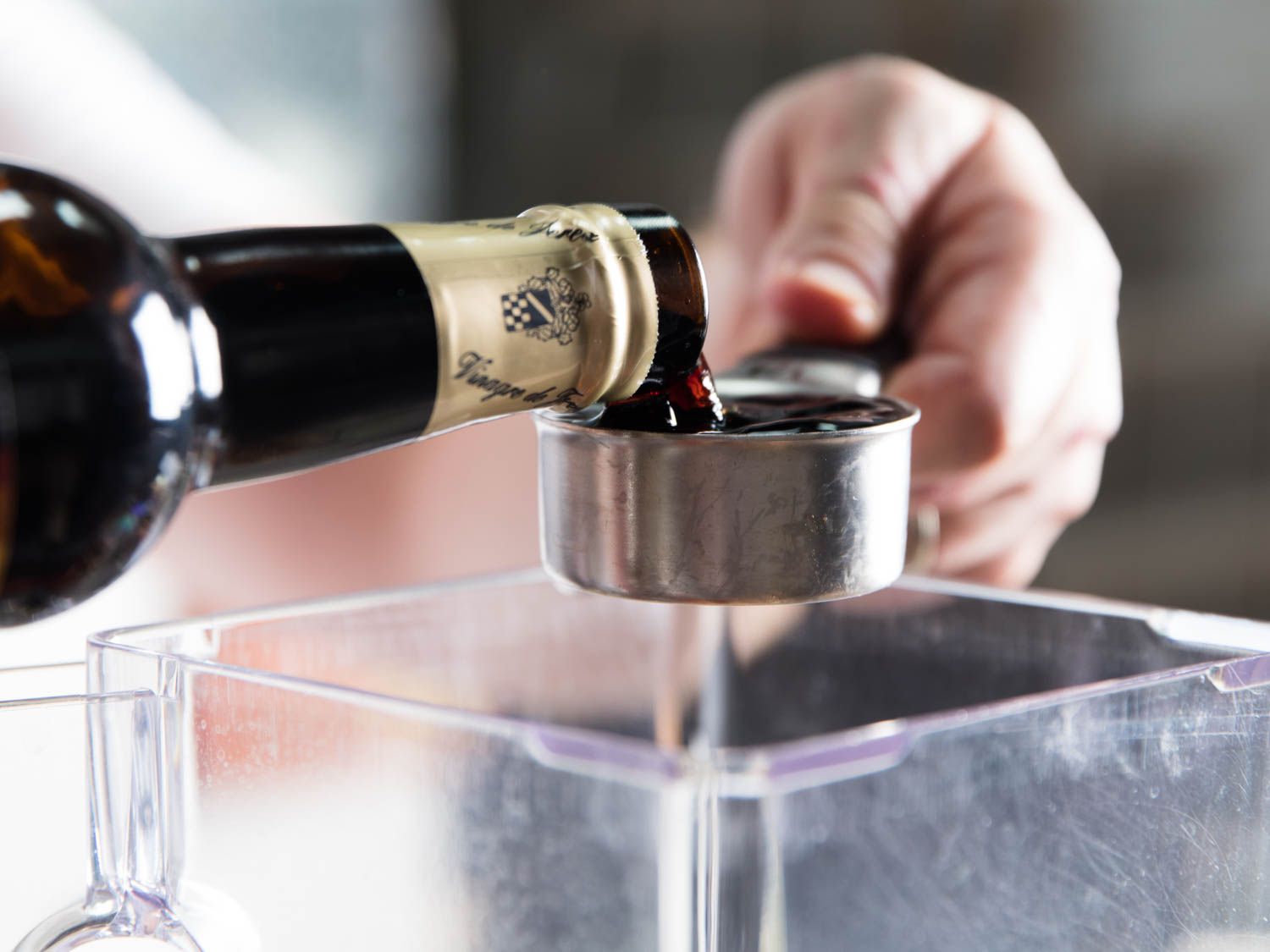 Pouring sherry vinegar into a measuring cup. 