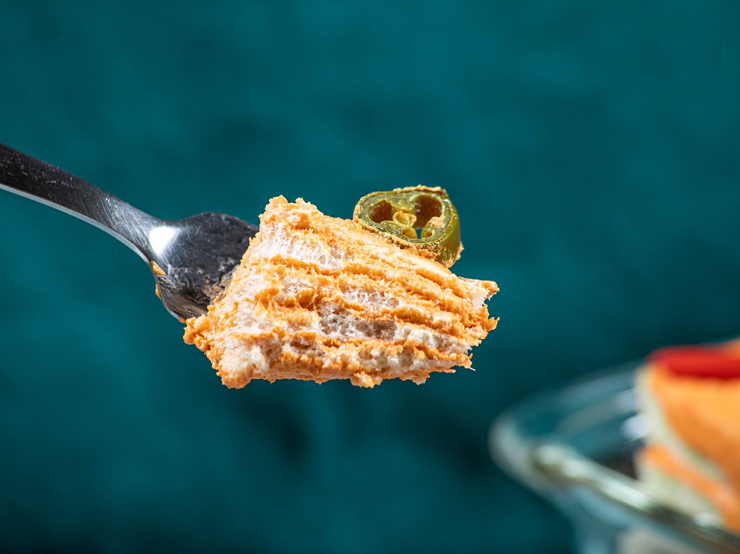 A close up view of a single bite of Pastel De Atun on a silver fork
