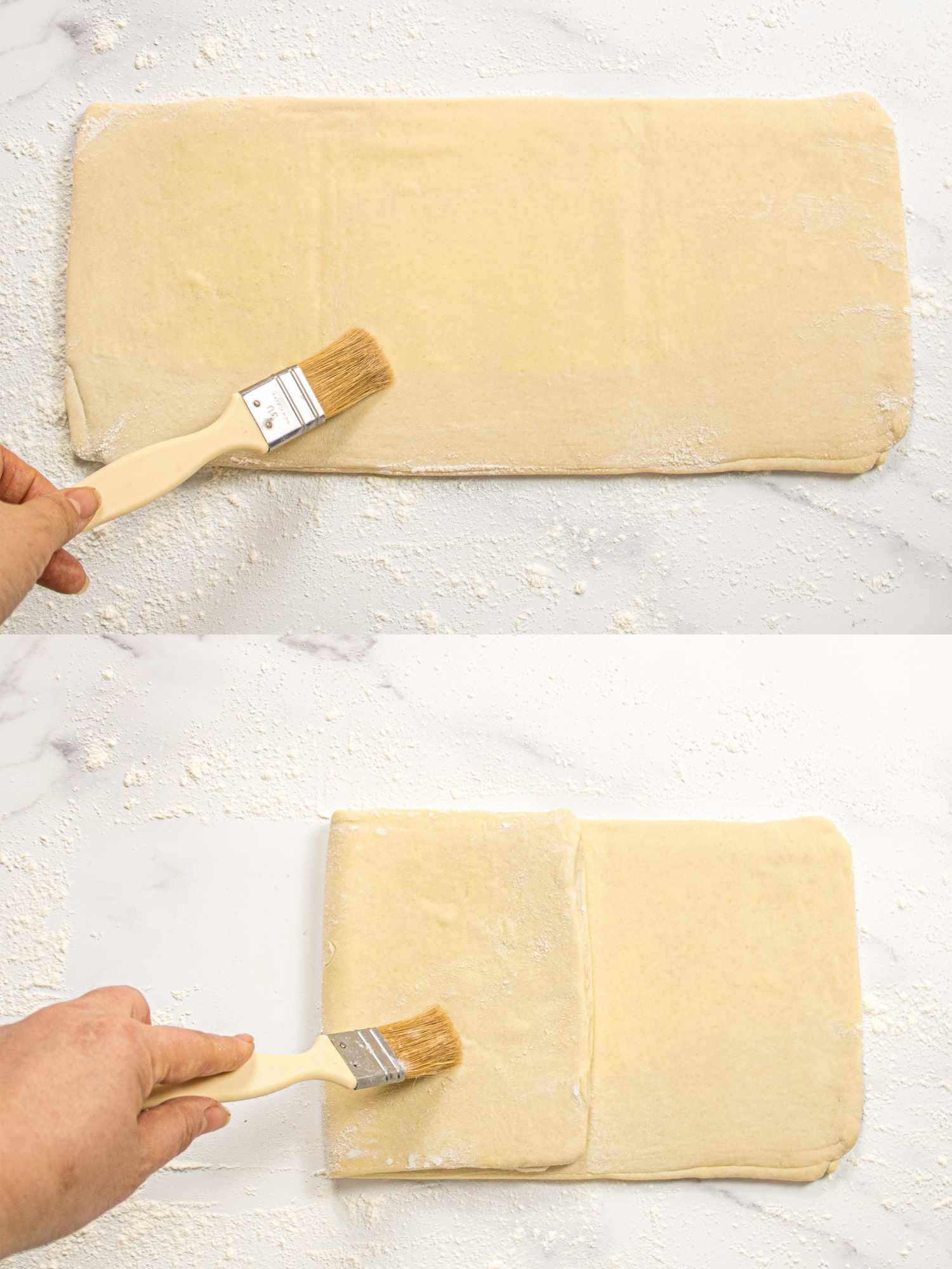 A hand applying a brush to pastry dough showing folding and preparation of the dough