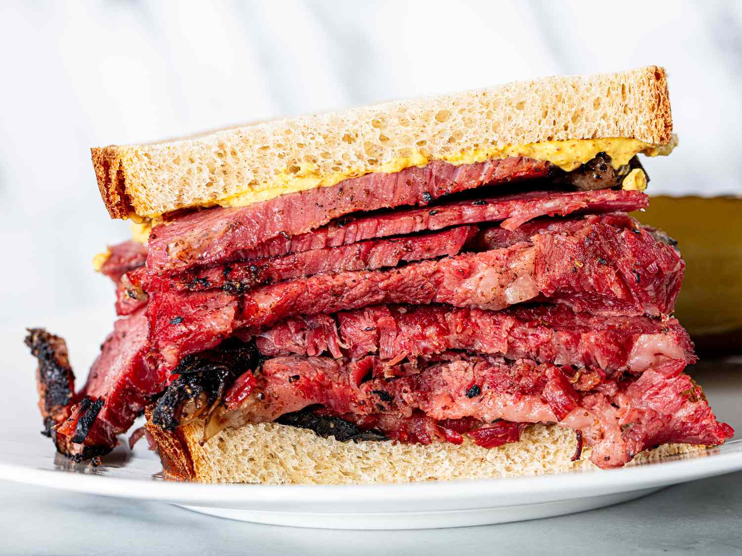 Close up of a pastrami on Jewish rye sandwich with spicy brown mustard