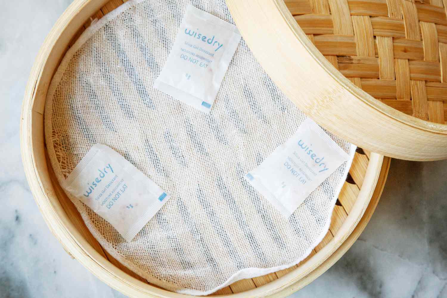 Three desiccant packs in a bamboo steamer