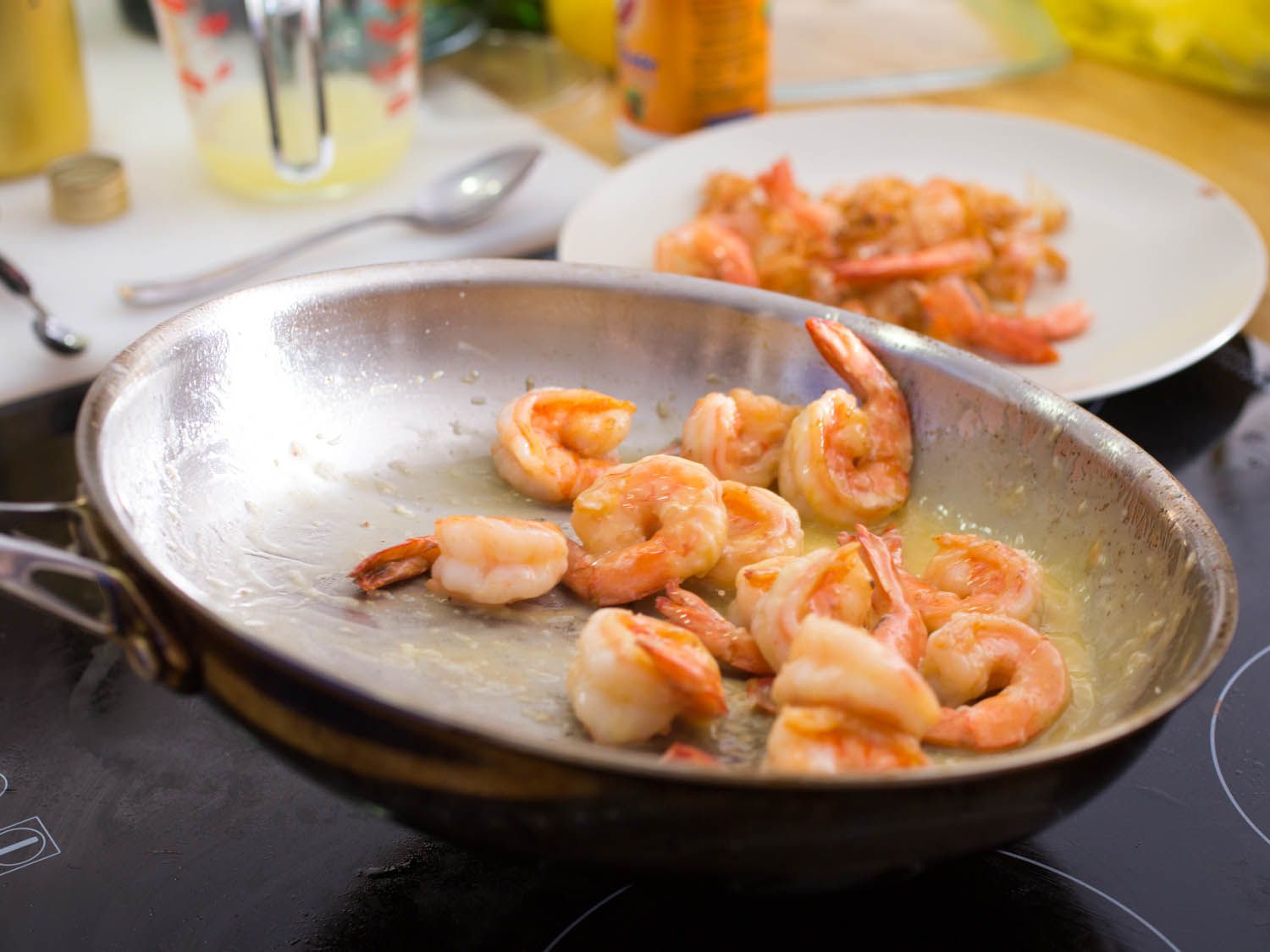 Shrimp being sautéed in butter in a pan for shrimp scampi.