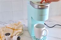 Keurig coffee machines k mini single on counter being used by person 