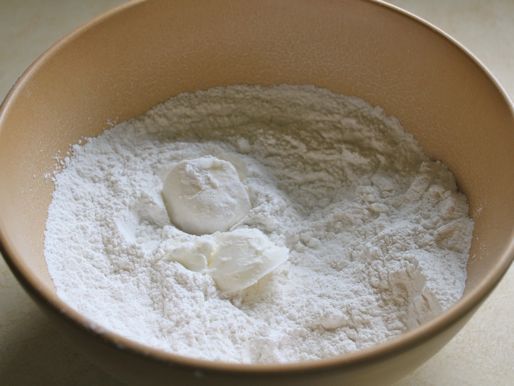 Two spoonfuls of lard have been added to a mixing bowl with the dry ingredients for gluten-free tortillas.