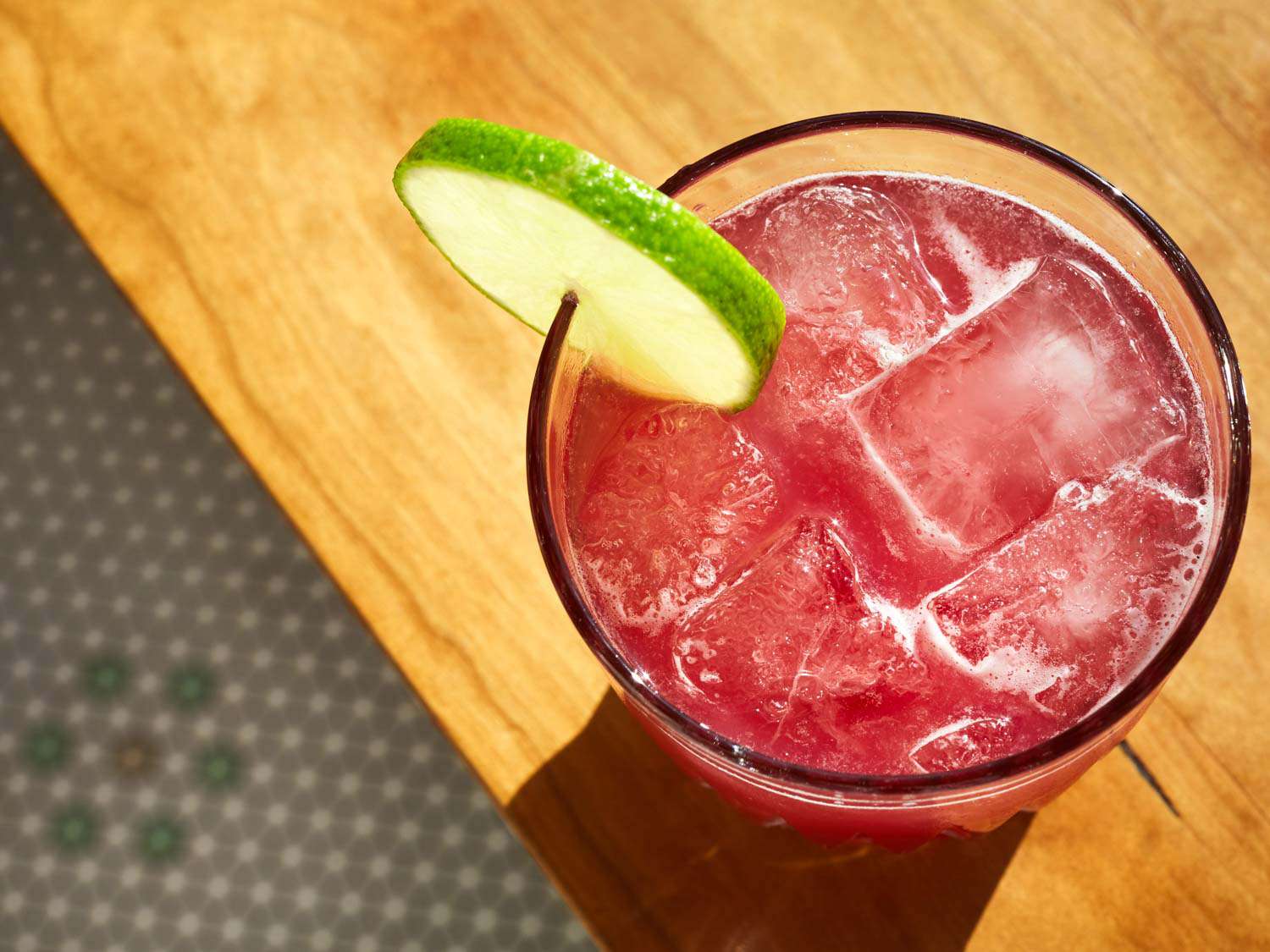 a pink cocktail with a lime wheel garnish at Elle