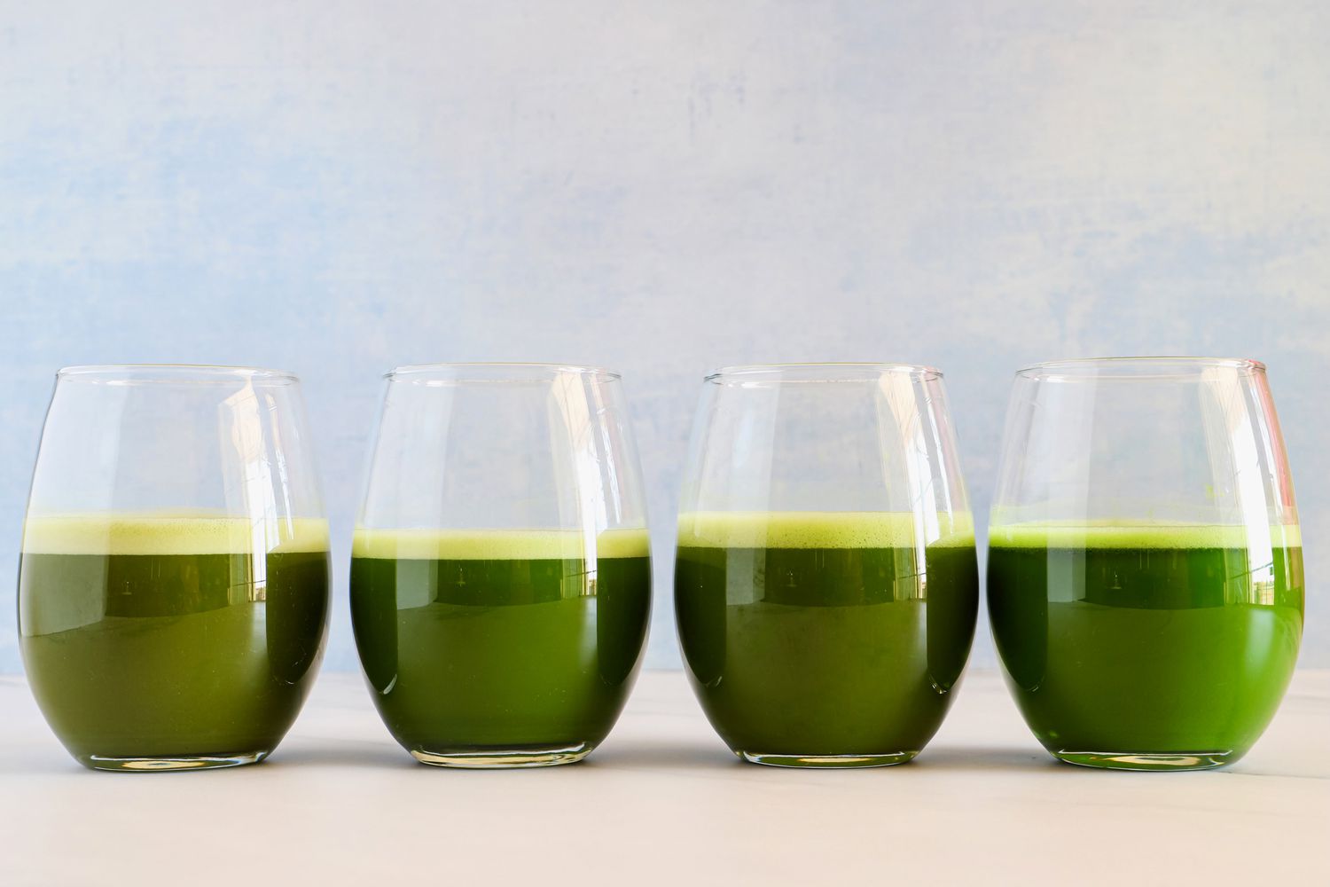 Four glasses with different matcha drinks in it.