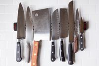A collection of knives on a metal knife strip