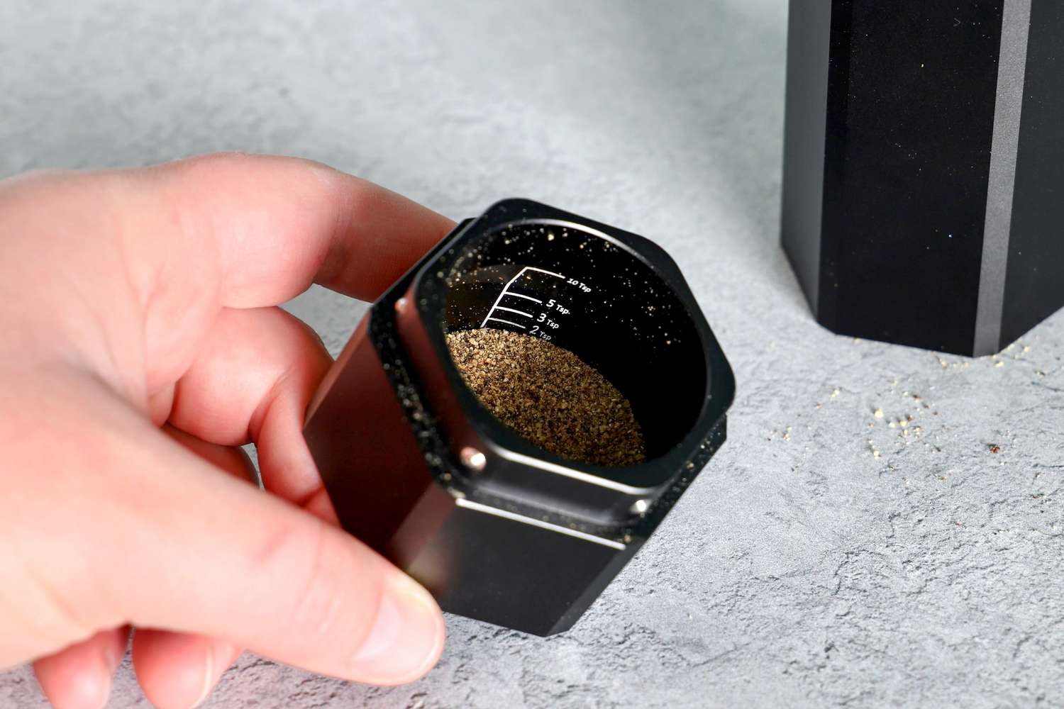 a closeup of the ground pepper in the catch basin of the grinder