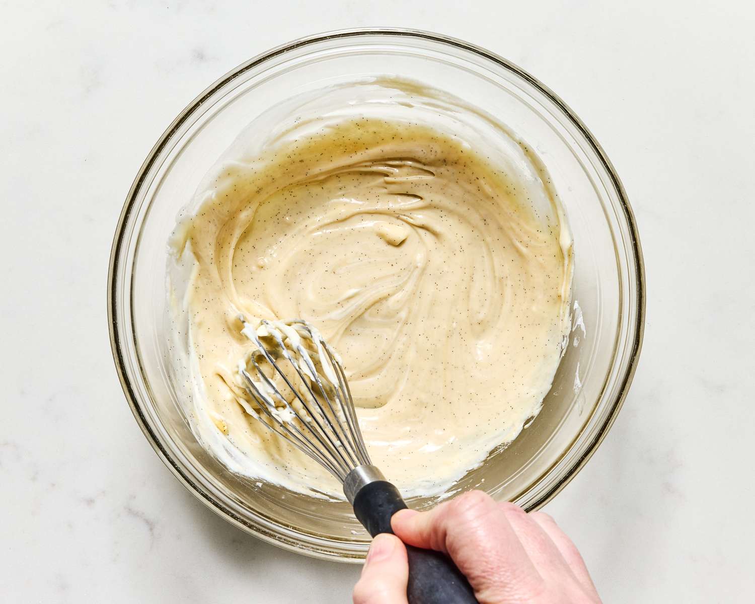 Hand whisking batter in a bowl