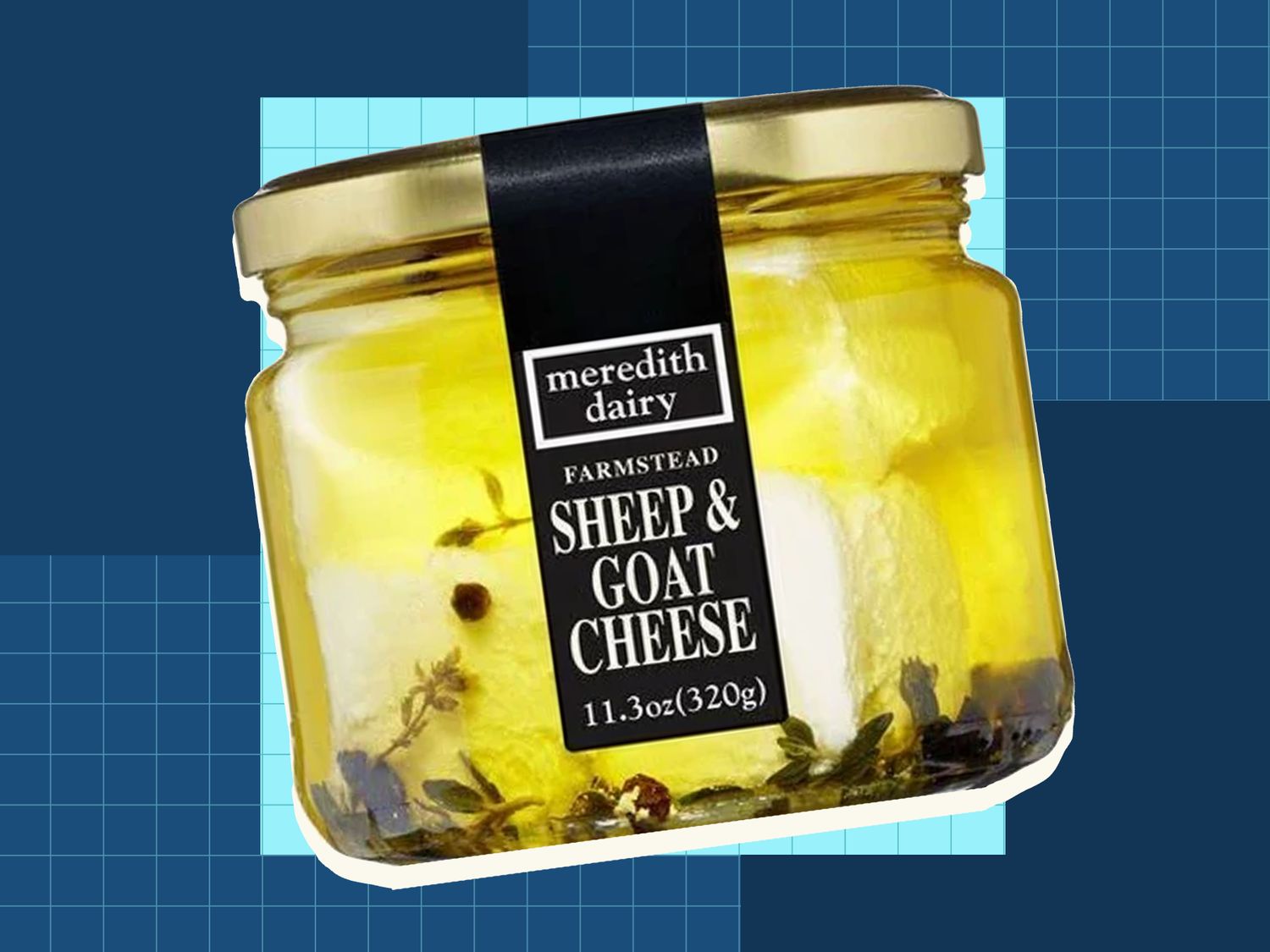 A jar of Meredith Dairy Sheep Goat Cheese with a net weight of 113 ounces displayed against a blue background with a grid pattern