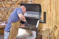 A person cleans the Yoder Smokers YS640S Pellet Grill