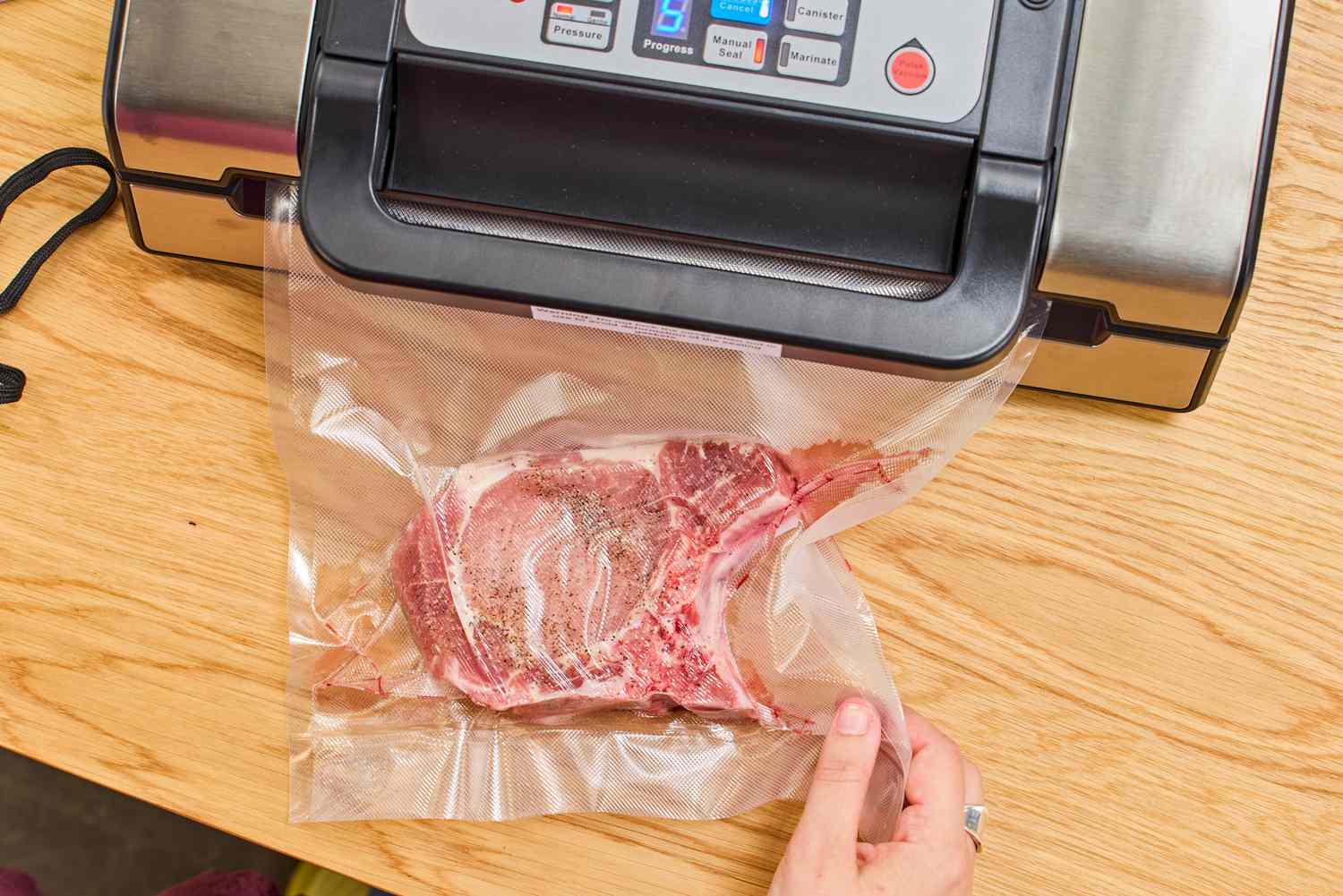 A steak being sealed in plastic with a Nesco vacuum sealer