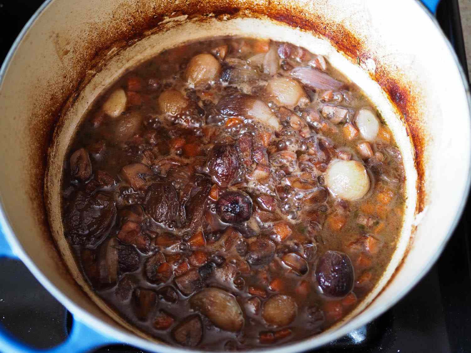 Overhead shot of finished coq au vin with chicken removed. All of the vegetables have been added to the braise.